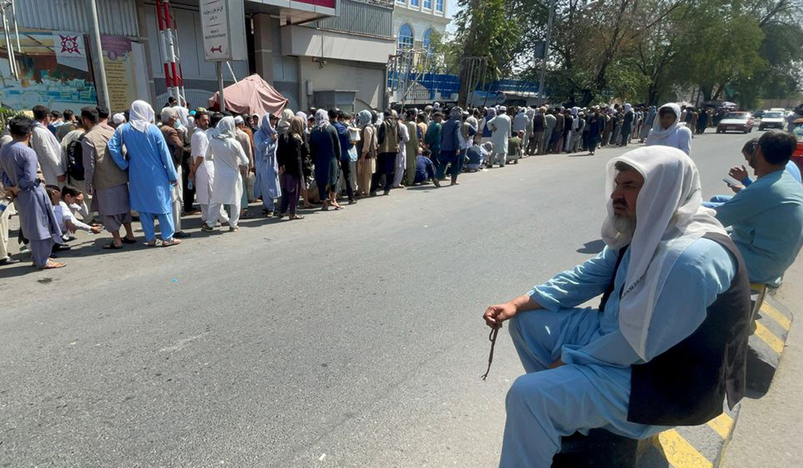 Afghans line up outside a bank to take out their money